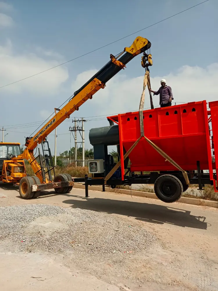 Crane lifting the hopper of a Shomas mobile grain dryer during loading for dispatch