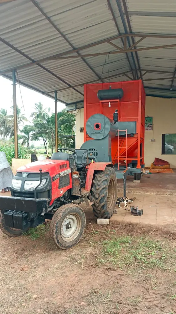 Shomas mobile grain dryer with a red tractor under a farm shed